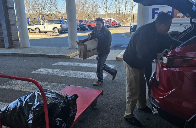 man carrying items onto cart