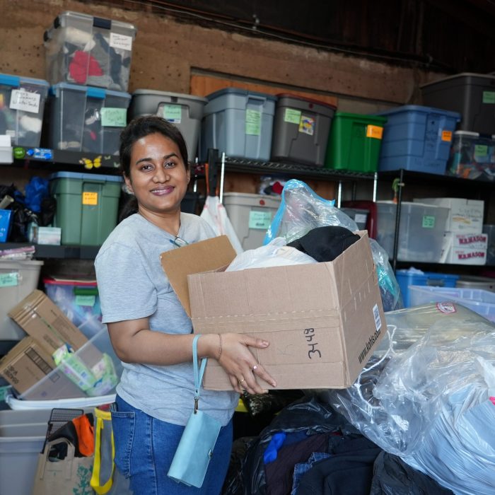 Shomrita Barua smiling and holding a box