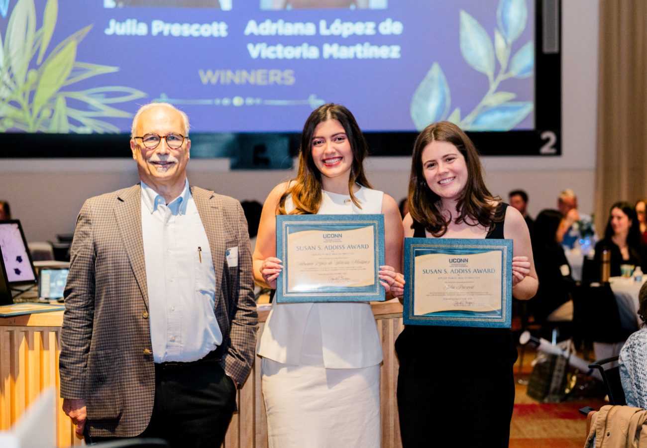 David Gregorio stands next awardees, Adriana Lopez and Julia Prescott at graduation dinner