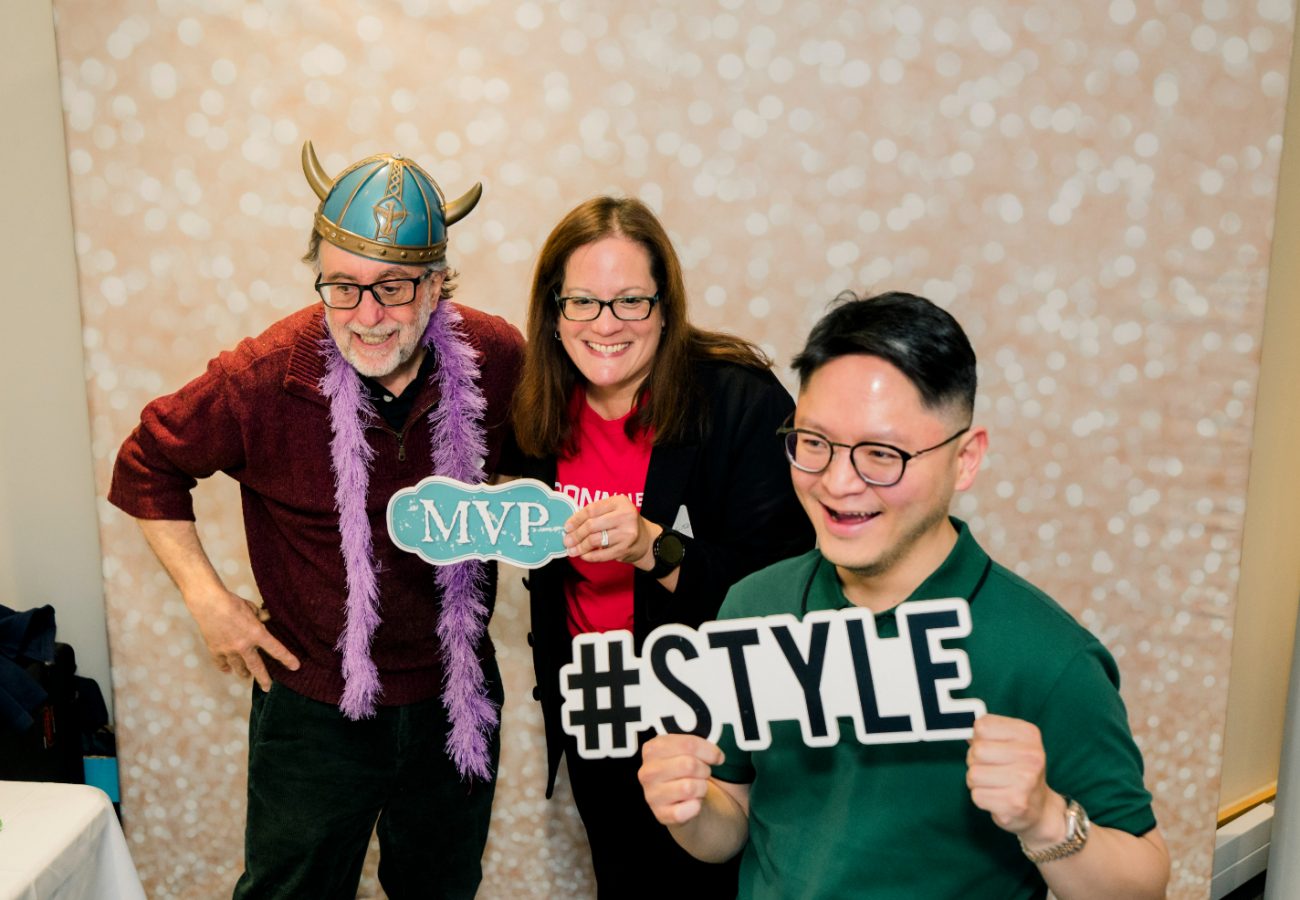 Doug Brugge, Angela Bermudez, Greg Rhee wearing photo props and smiling at the camera